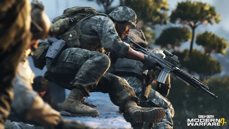 Soldier aiming a rifle with squadmates in forest cover